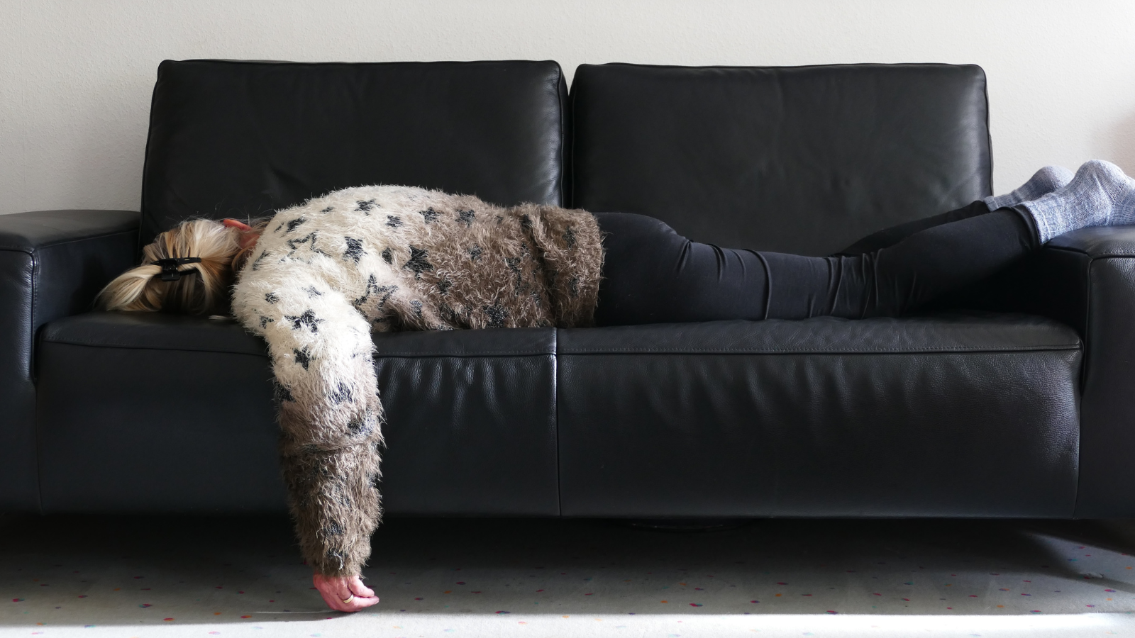 Vermoeide vrouw ligt uitgeput op de bank door stress en gebrek aan herstel